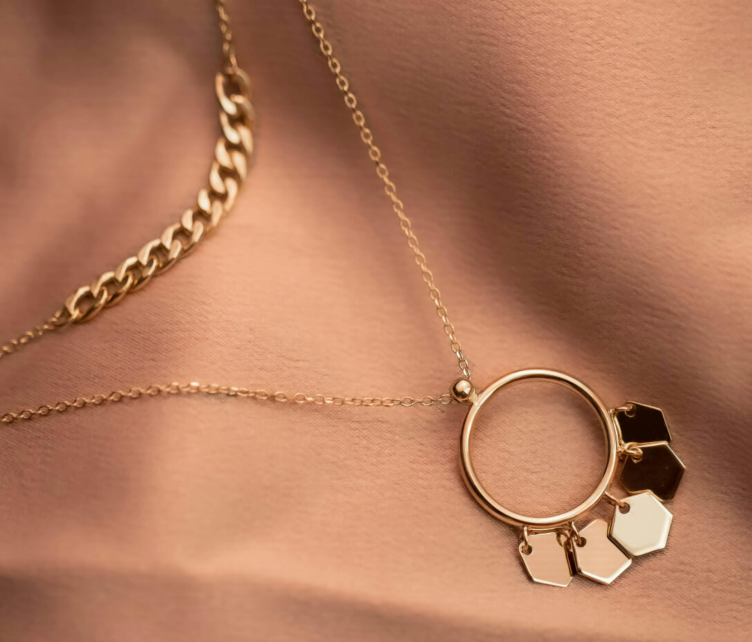 Gold circle pendant hung with polished hexagon charms