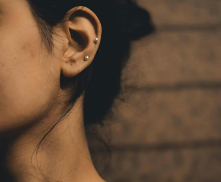Freshwater pearl stud earrings worn in a double lobe piercing